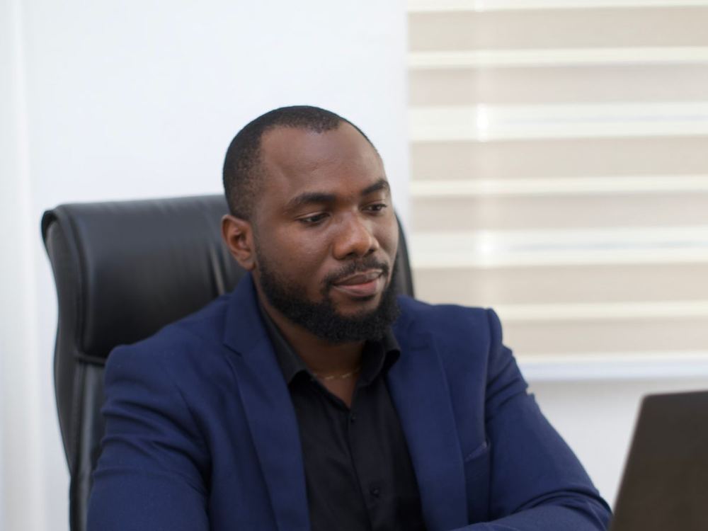 An accountant working at a laptop in an office in Abuja.